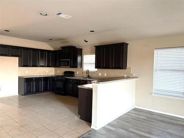 a kitchen with stainless steel appliances granite countertop a stove a sink and a microwave