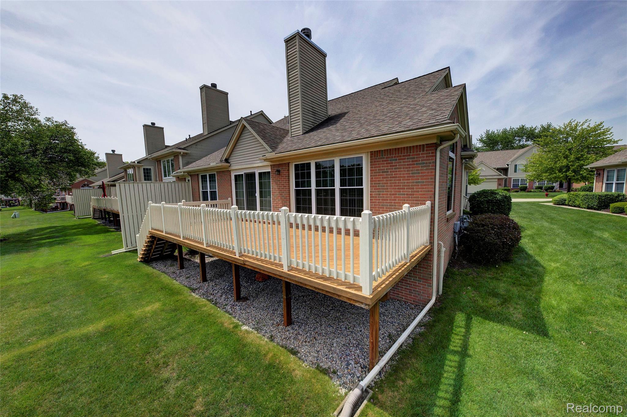 2577 Cleveland Way Canton, MI 48188 - Photo 28 of 34 Back of property featuring a wooden deck, a chimney, brick siding, and roof with shingles