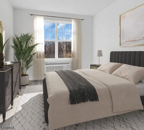 a bedroom with a large bed and a large window a potted plant on the dresser