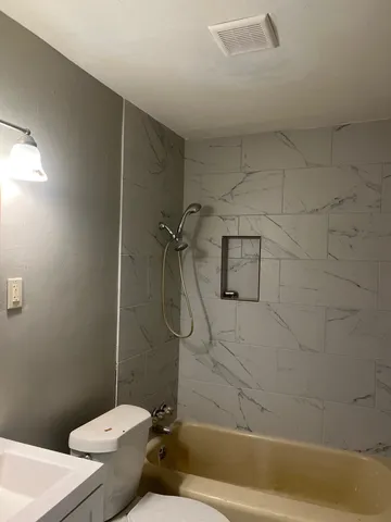 a bathroom with a toilet and shower