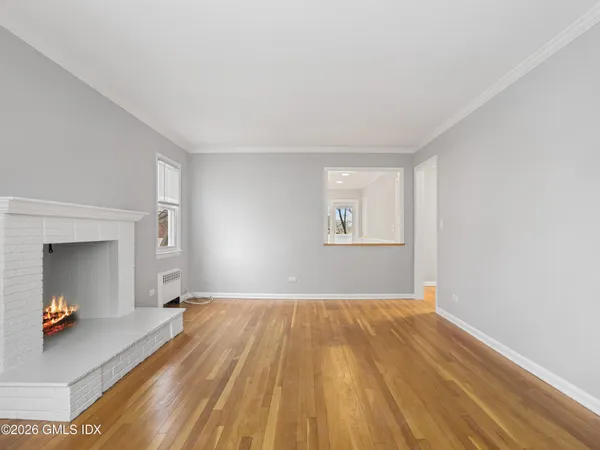 a view of a bedroom with wooden floor and a window
