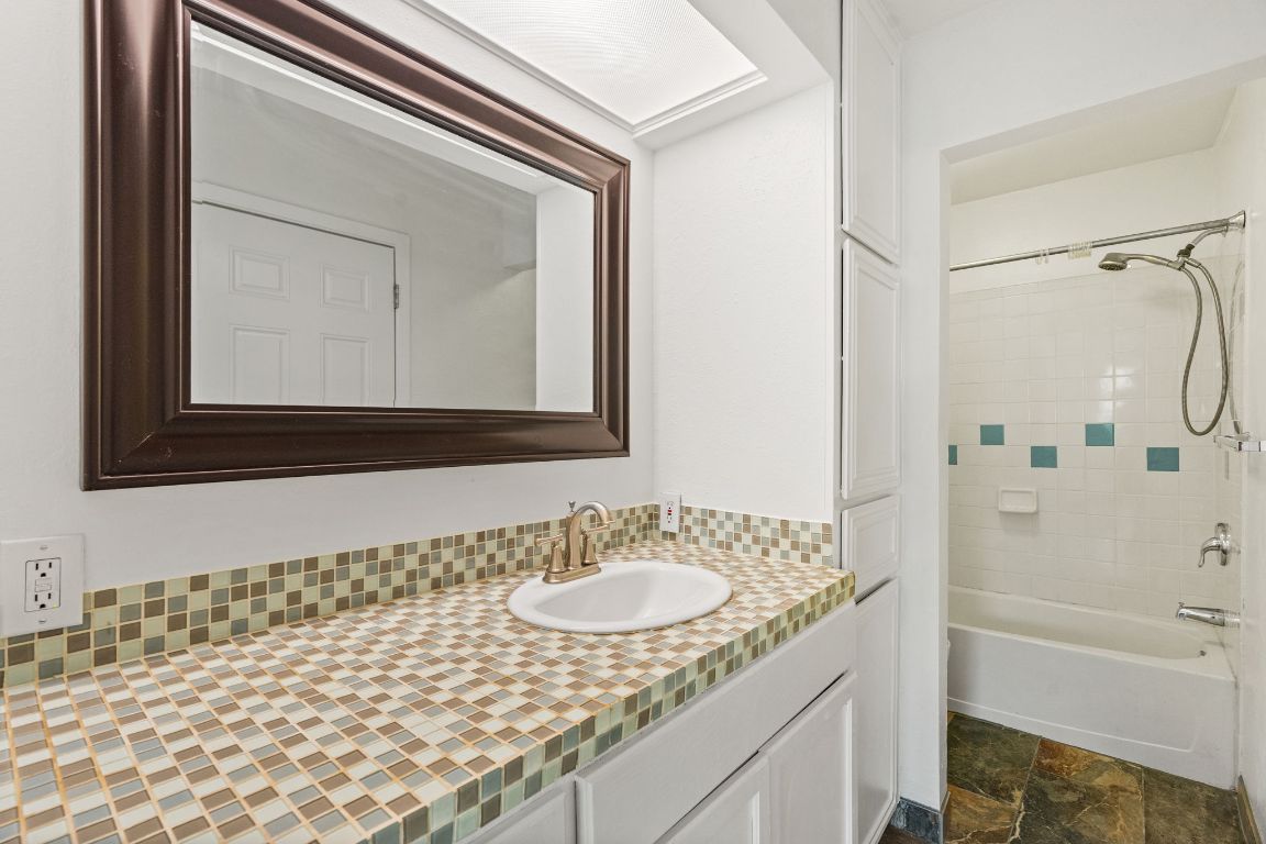 2406 Berkeley Avenue, Unit B Austin, TX 78745 - Photo 16 of 24 a bathroom with a granite countertop sink and a mirror