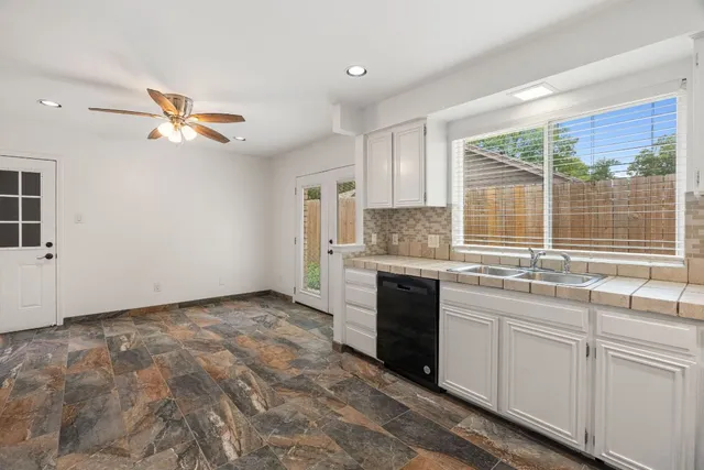 a kitchen with granite countertop a sink stainless steel appliances and cabinets