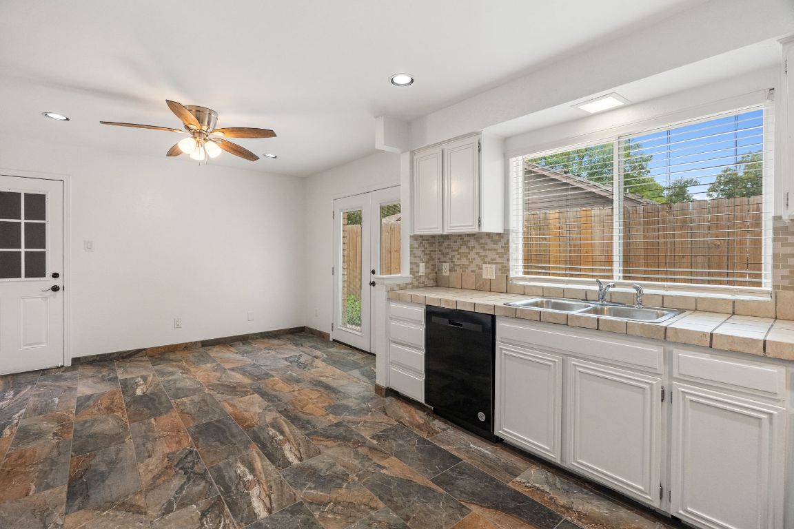 2406 Berkeley Avenue, Unit B Austin, TX 78745 - Photo 8 of 24 a kitchen with granite countertop a sink stainless steel appliances and cabinets