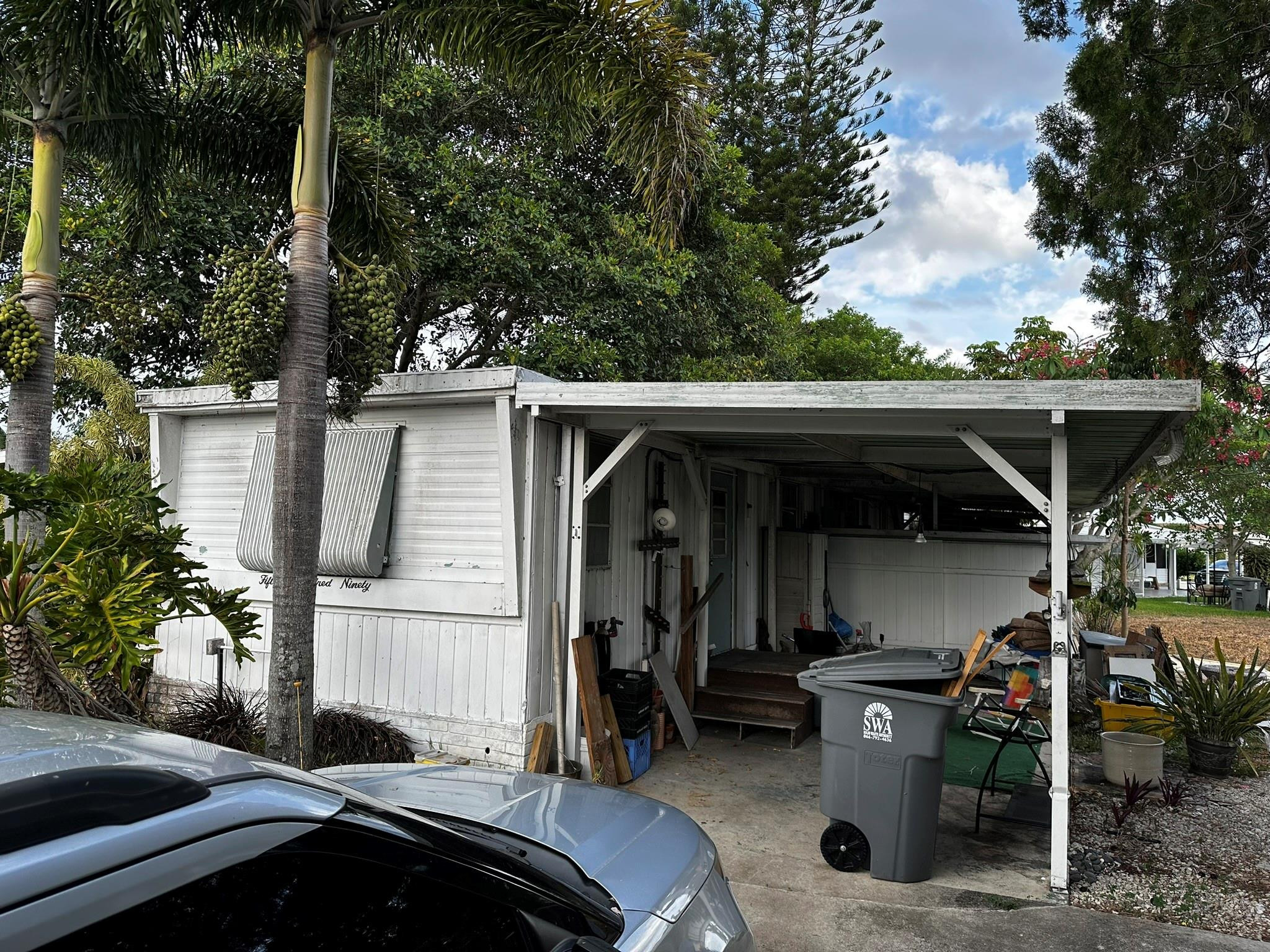 1590 Southwest 65th Terrace Boca Raton, FL 33428 - Photo 2 of 13 a front view of house with yard outdoor seating and barbeque oven