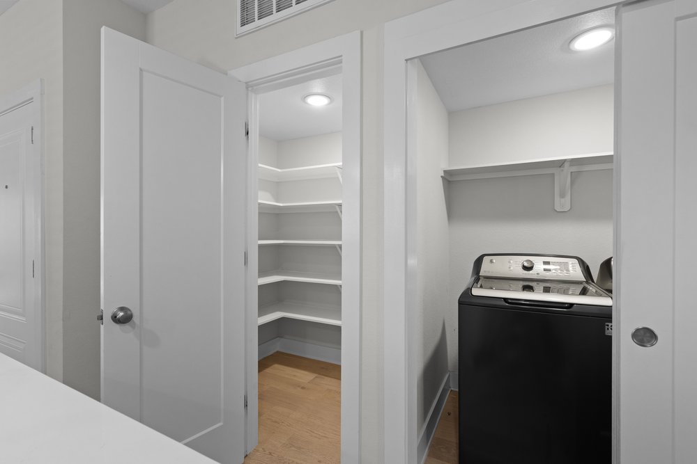 2827 Manor Road, Unit 2201 Austin, TX 78722 - Photo 17 of 40 Walk-in pantry with light wood-finish flooring and multiple corner shelves, alongside a laundry closet with a built-in shelf