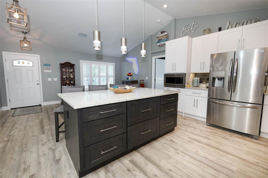 424 Meadow Green Drive Davenport, FL 33837 - Photo 11 of 47 a kitchen with a refrigerator a sink dishwasher a oven a dining table and chairs with wooden floor