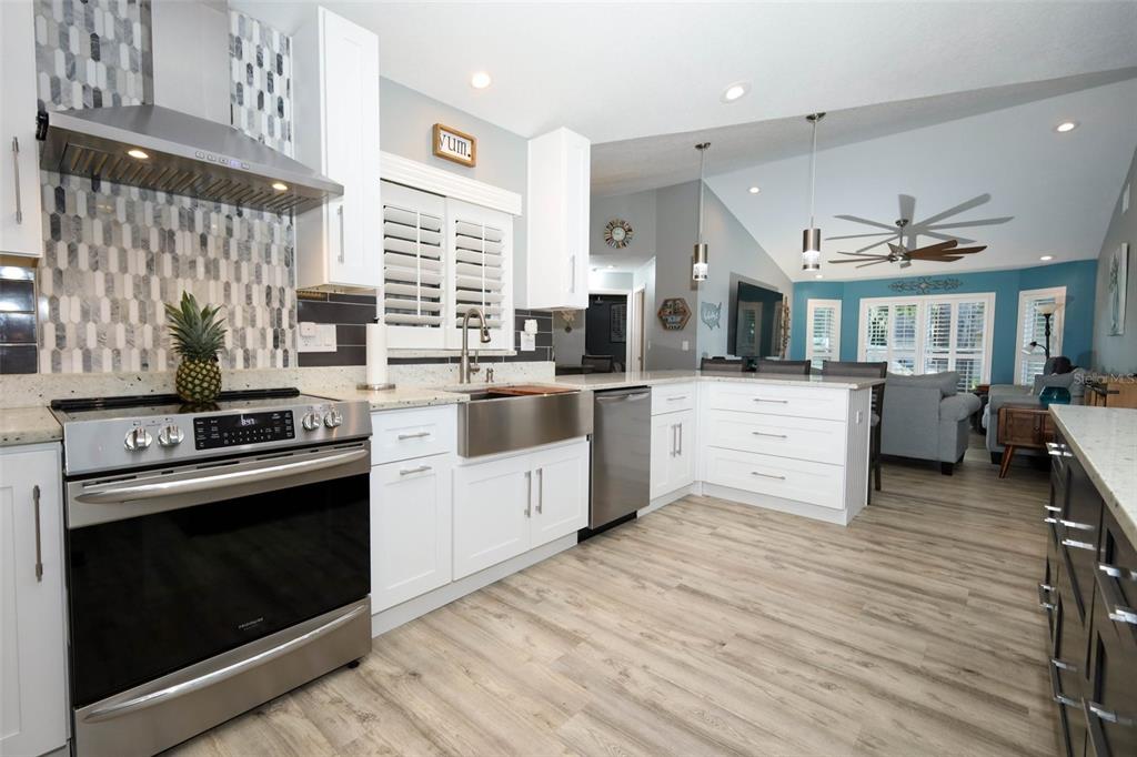 424 Meadow Green Drive Davenport, FL 33837 - Photo 14 of 47 a kitchen with stainless steel appliances granite countertop a stove oven and white cabinets