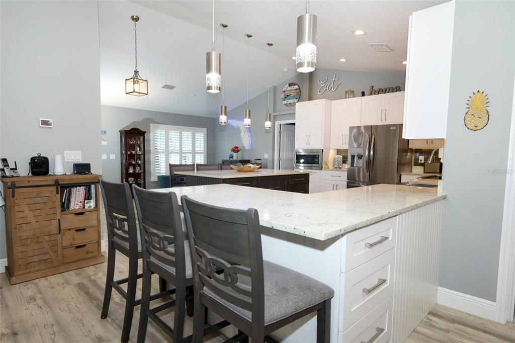 424 Meadow Green Drive Davenport, FL 33837 - Photo 21 of 47 a kitchen with stainless steel appliances kitchen island granite countertop a table chairs and a refrigerator