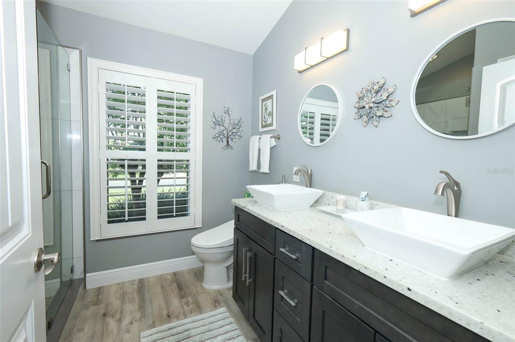 424 Meadow Green Drive Davenport, FL 33837 - Photo 26 of 47 a bathroom with a granite countertop toilet a sink and a mirror