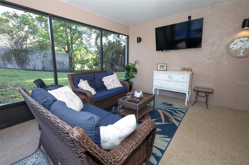 424 Meadow Green Drive Davenport, FL 33837 - Photo 34 of 47 a living room with furniture a flat screen tv and a floor to ceiling window