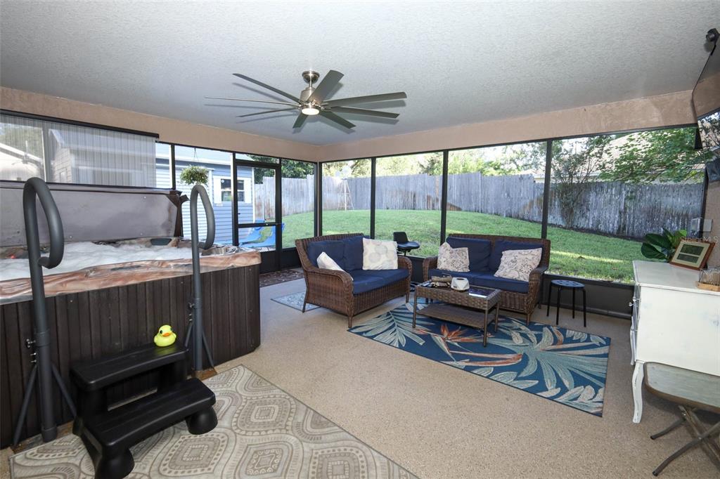 424 Meadow Green Drive Davenport, FL 33837 - Photo 38 of 47 a living room with furniture and a floor to ceiling window