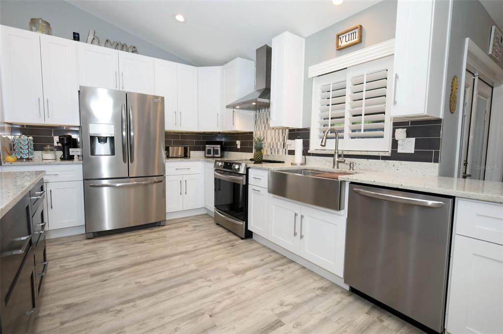 424 Meadow Green Drive Davenport, FL 33837 - Photo 9 of 47 a kitchen with granite countertop a refrigerator sink and wooden floor