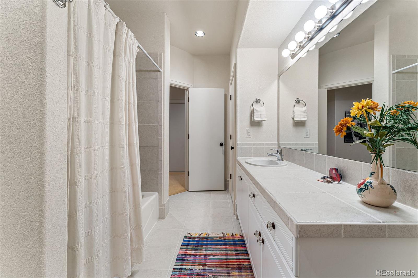 395 Timber Lane Boulder, CO 80304 - Photo 27 of 37 a bathroom with a sink a potted plant and a large mirror