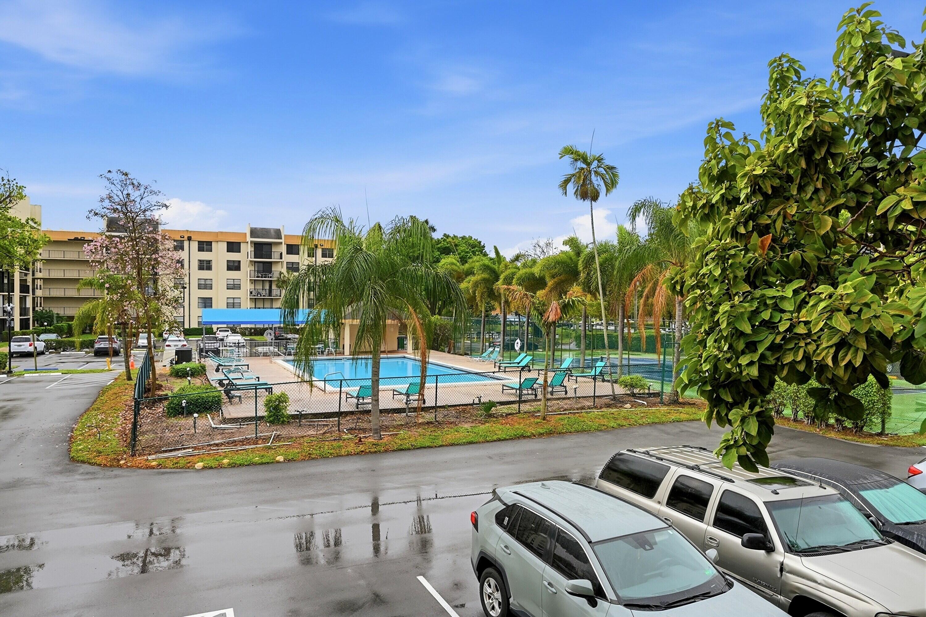 6195 Rock Island Road, Unit 210 Tamarac, FL 33319 - Photo 26 of 26 a view of a swimming pool with lawn chairs and palm trees