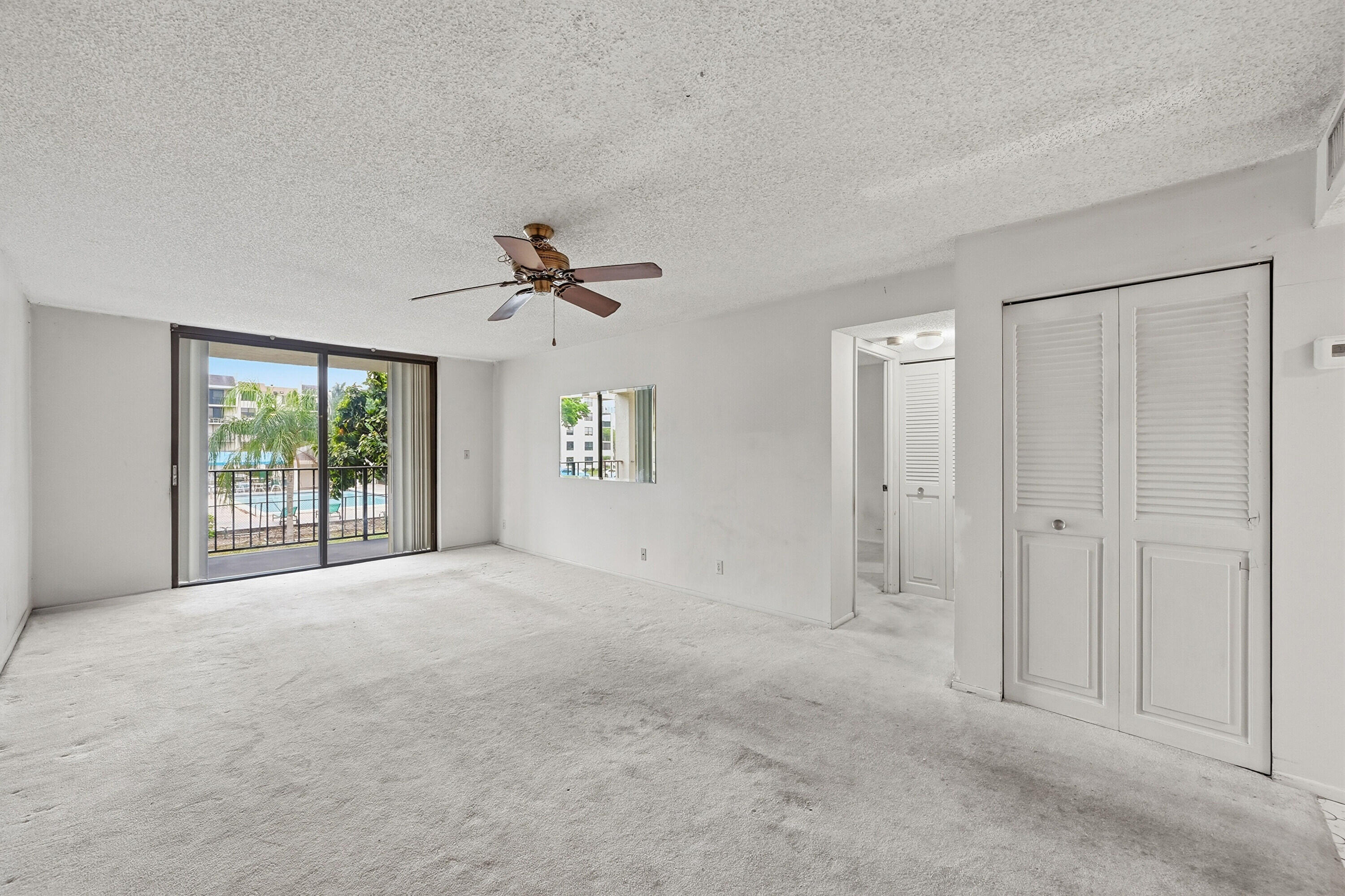 6195 Rock Island Road, Unit 210 Tamarac, FL 33319 - Photo 5 of 26 a view of a big room with windows and chandelier fan