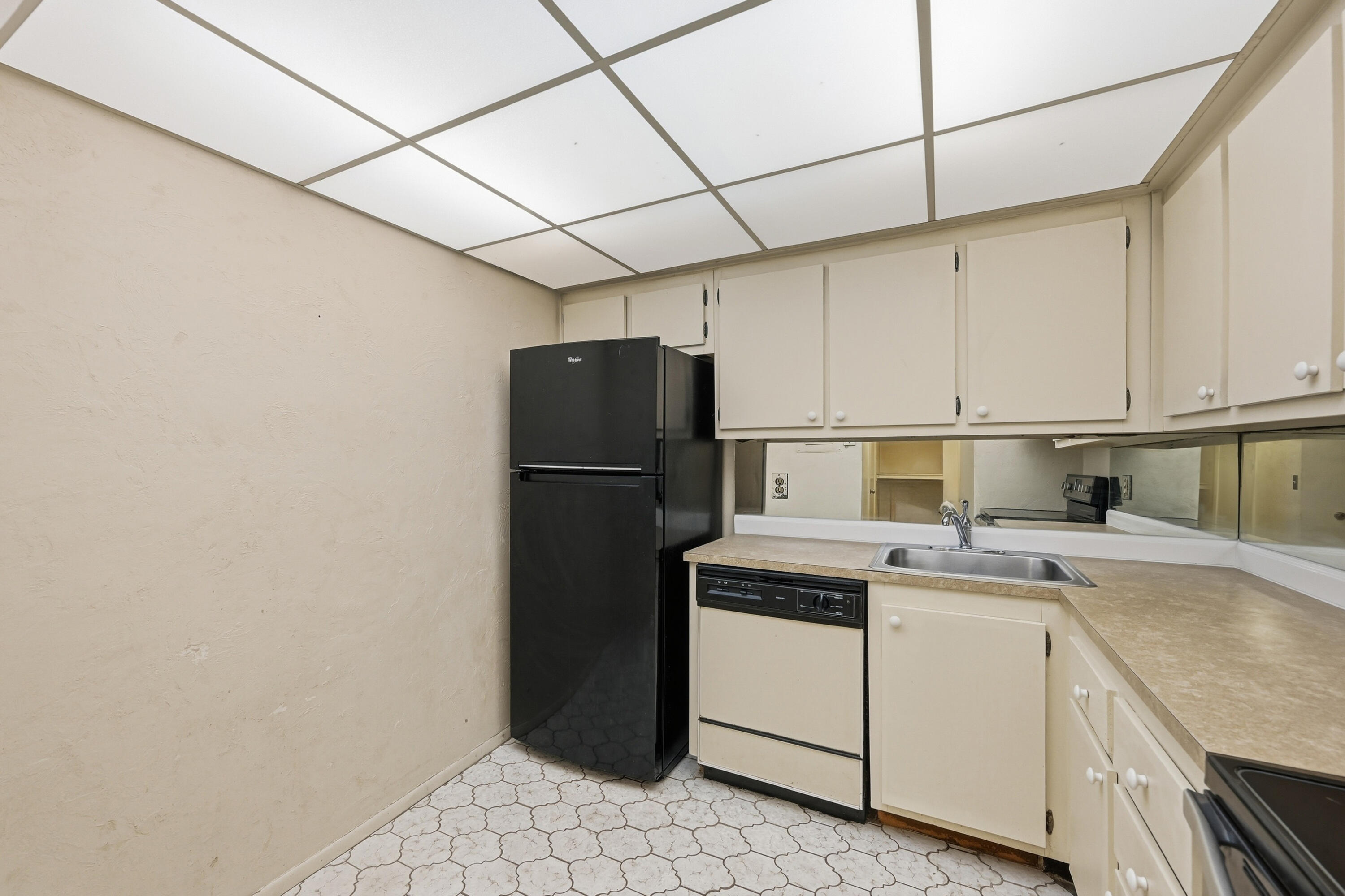 6195 Rock Island Road, Unit 210 Tamarac, FL 33319 - Photo 8 of 26 a kitchen with a sink a refrigerator and cabinets