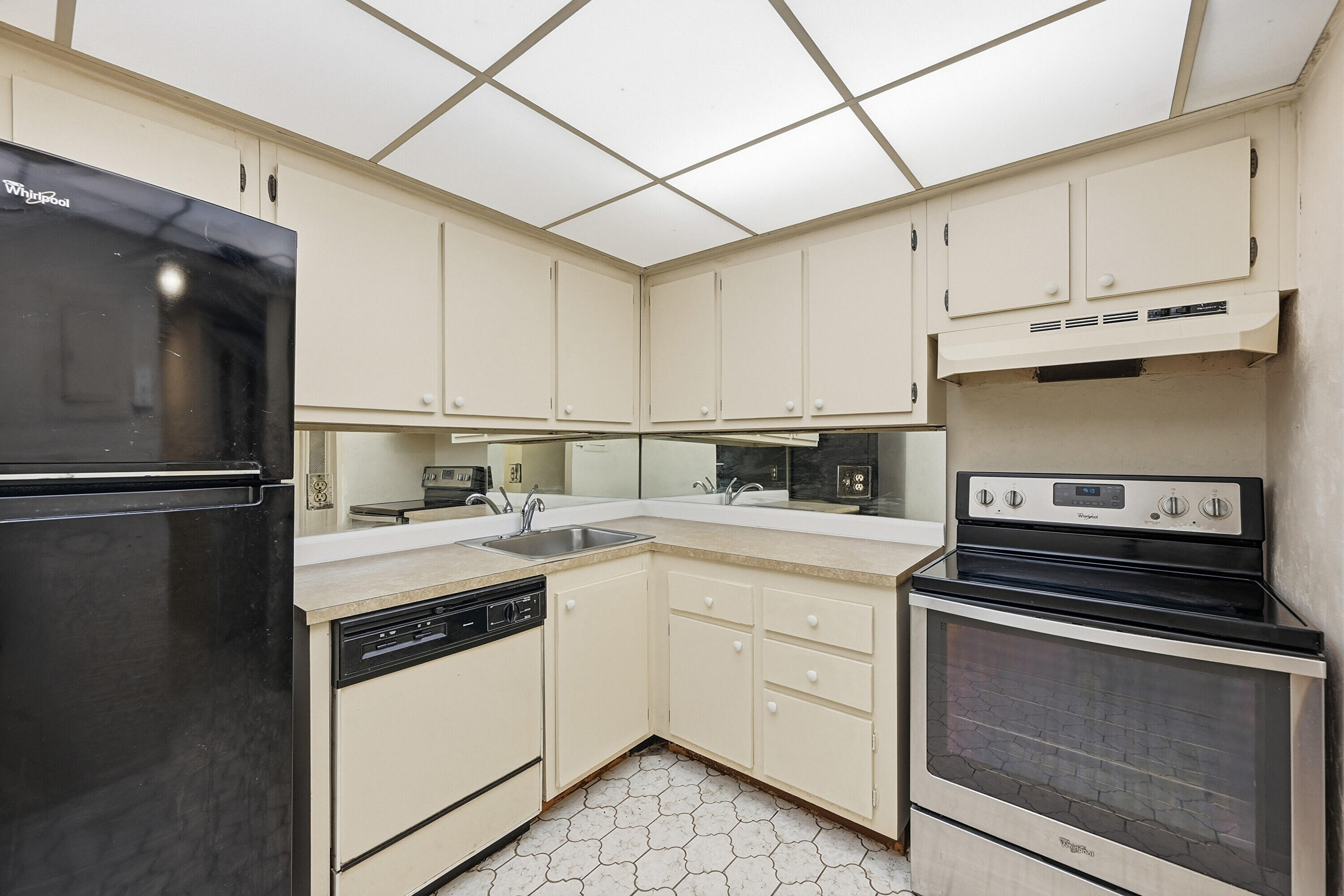 6195 Rock Island Road, Unit 210 Tamarac, FL 33319 - Photo 9 of 26 a kitchen with a stove cabinets and a refrigerator