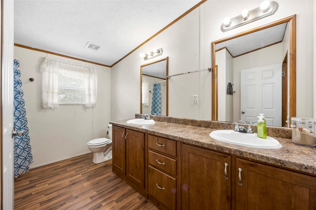 10020 Lavender Road Crowley, TX 76036 - Photo 17 of 25 Bathroom featuring double vanity, ornamental molding, a shower with shower curtain, and dark wood finished floors