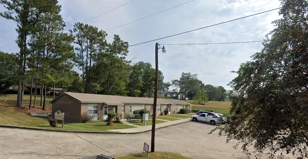 a view of a park that has a street sign and a tree