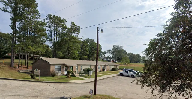 a view of a park that has a street sign and a tree