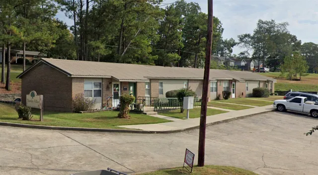 a view of a white house with a big yard and large tree