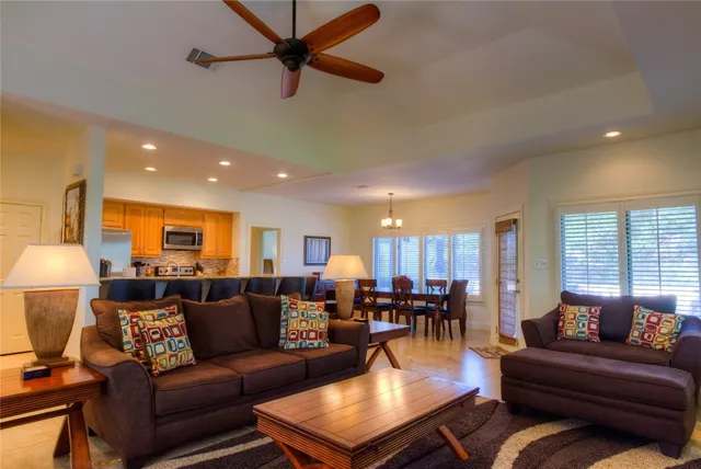 a living room with furniture kitchen view and a window