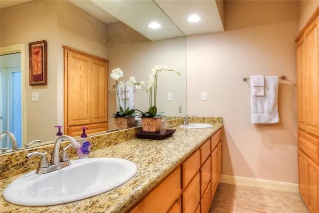 a bathroom with a granite countertop sink and a mirror