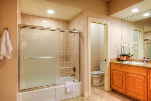 a bathroom with a granite countertop sink toilet and shower