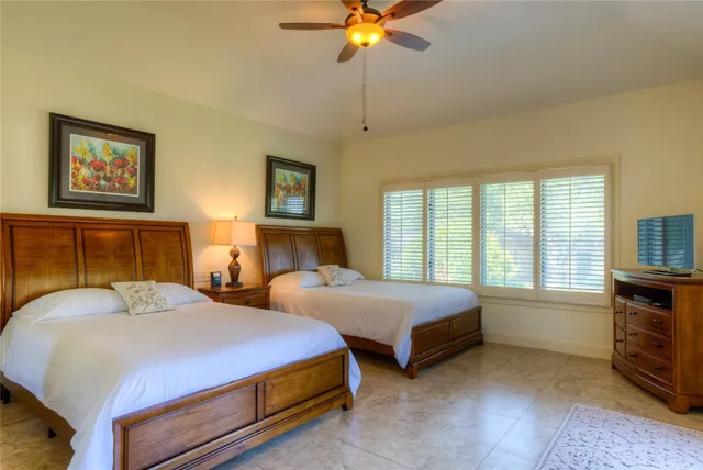 a bedroom with two beds and a chandelier