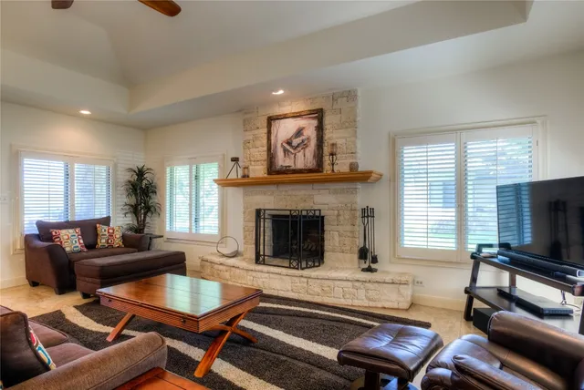 a living room with furniture a flat screen tv and a fireplace