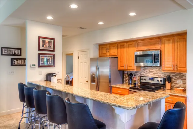 a kitchen with stainless steel appliances granite countertop a sink and a refrigerator