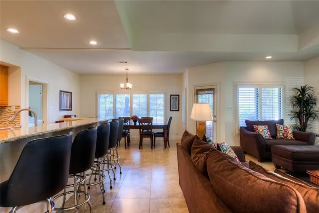 a living room with furniture kitchen view and a large window