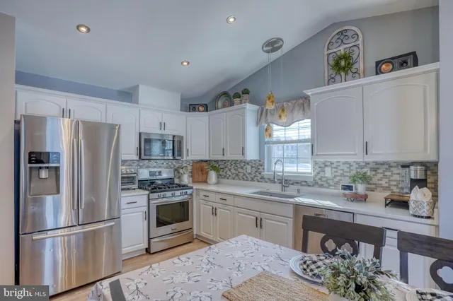 a kitchen with a sink stainless steel appliances and cabinets