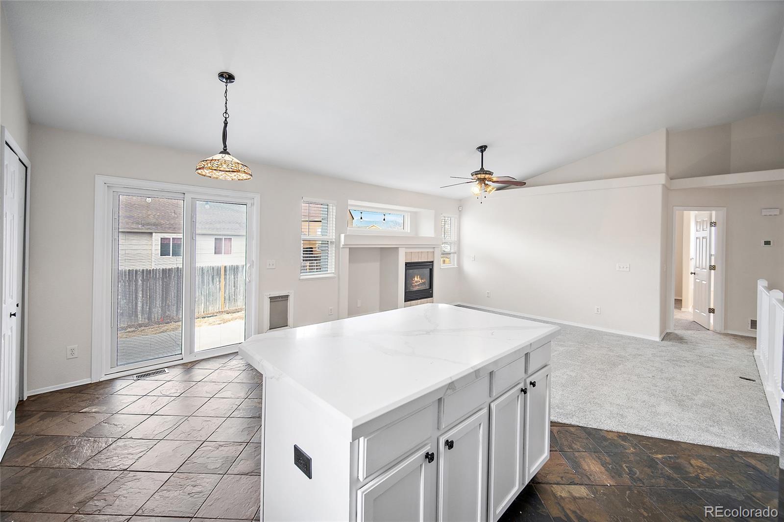 11360 Berry Farm Road Fountain, CO 80817 - Photo 15 of 44 a kitchen with kitchen island a counter top space appliances and cabinets