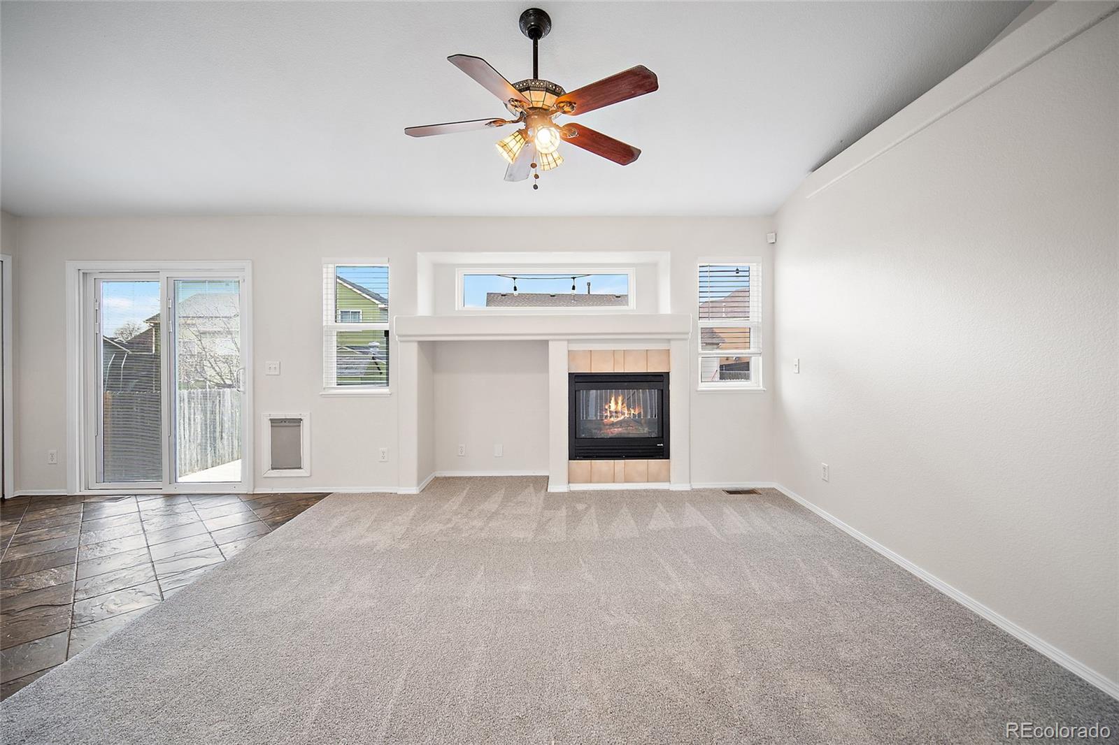 11360 Berry Farm Road Fountain, CO 80817 - Photo 17 of 44 an empty room with windows and fireplace