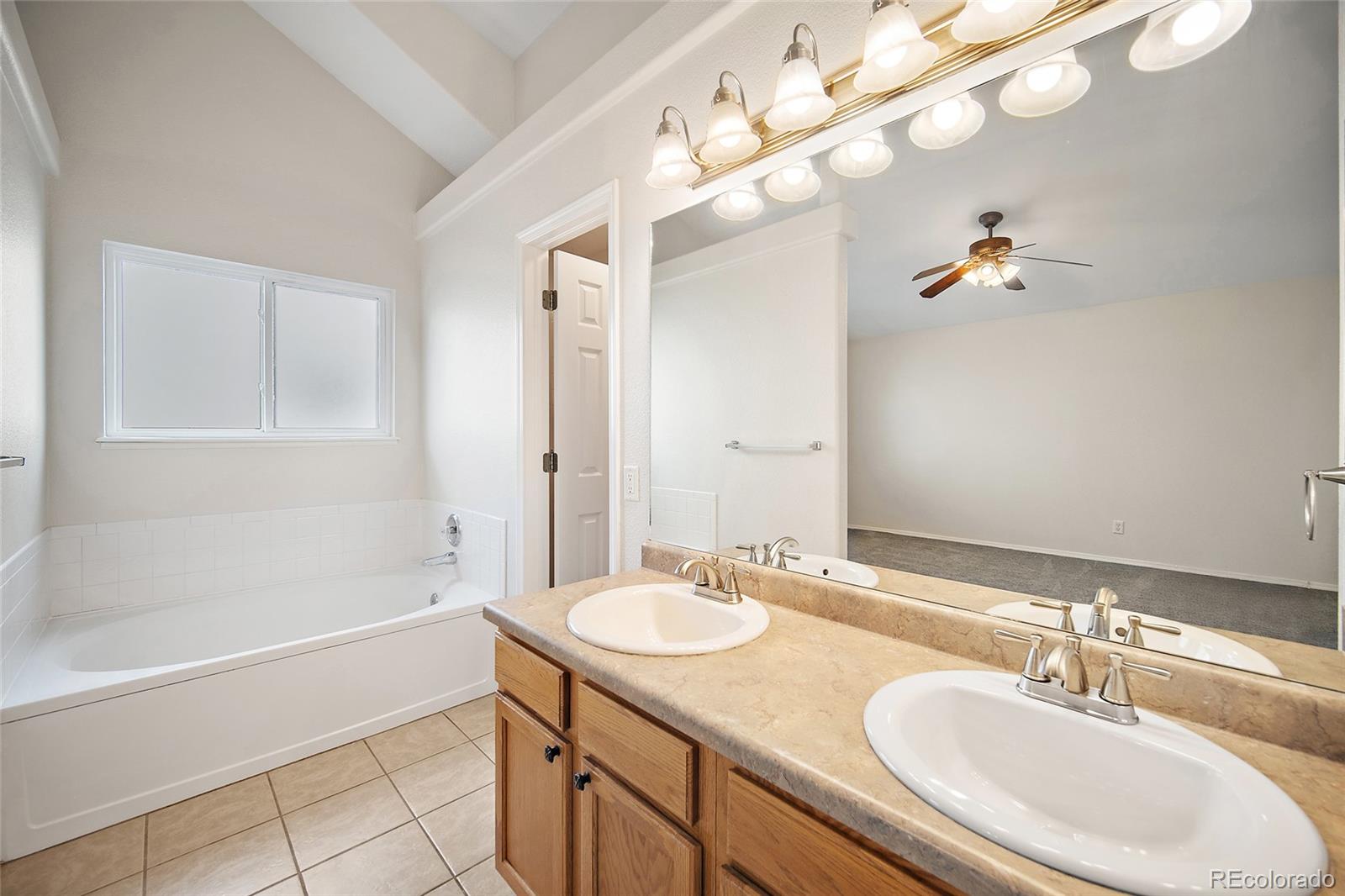 11360 Berry Farm Road Fountain, CO 80817 - Photo 23 of 44 a bathroom with a granite countertop sink a large mirror and a bathtub