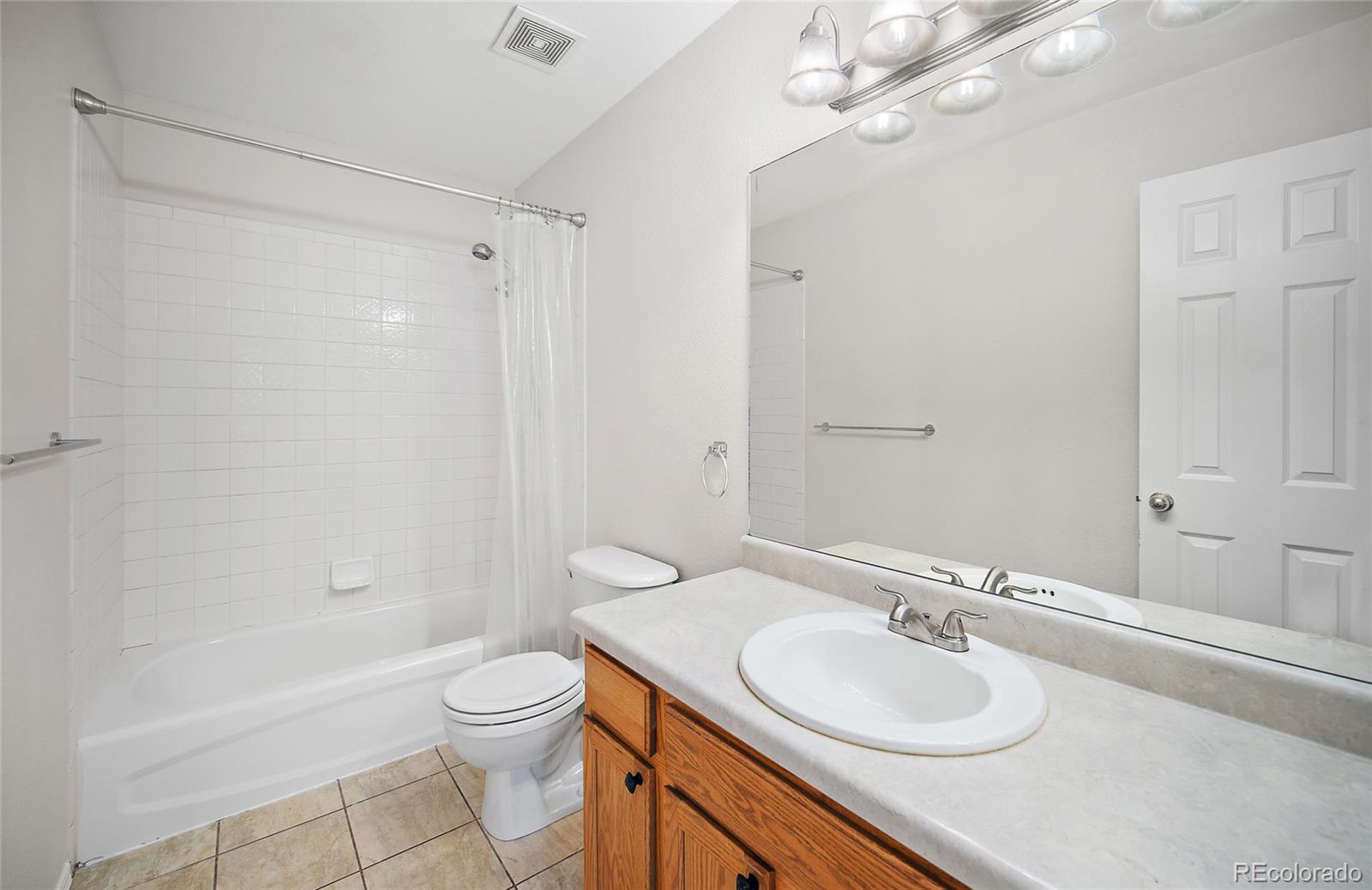 11360 Berry Farm Road Fountain, CO 80817 - Photo 26 of 44 a bathroom with a granite countertop sink toilet a shower and a mirror
