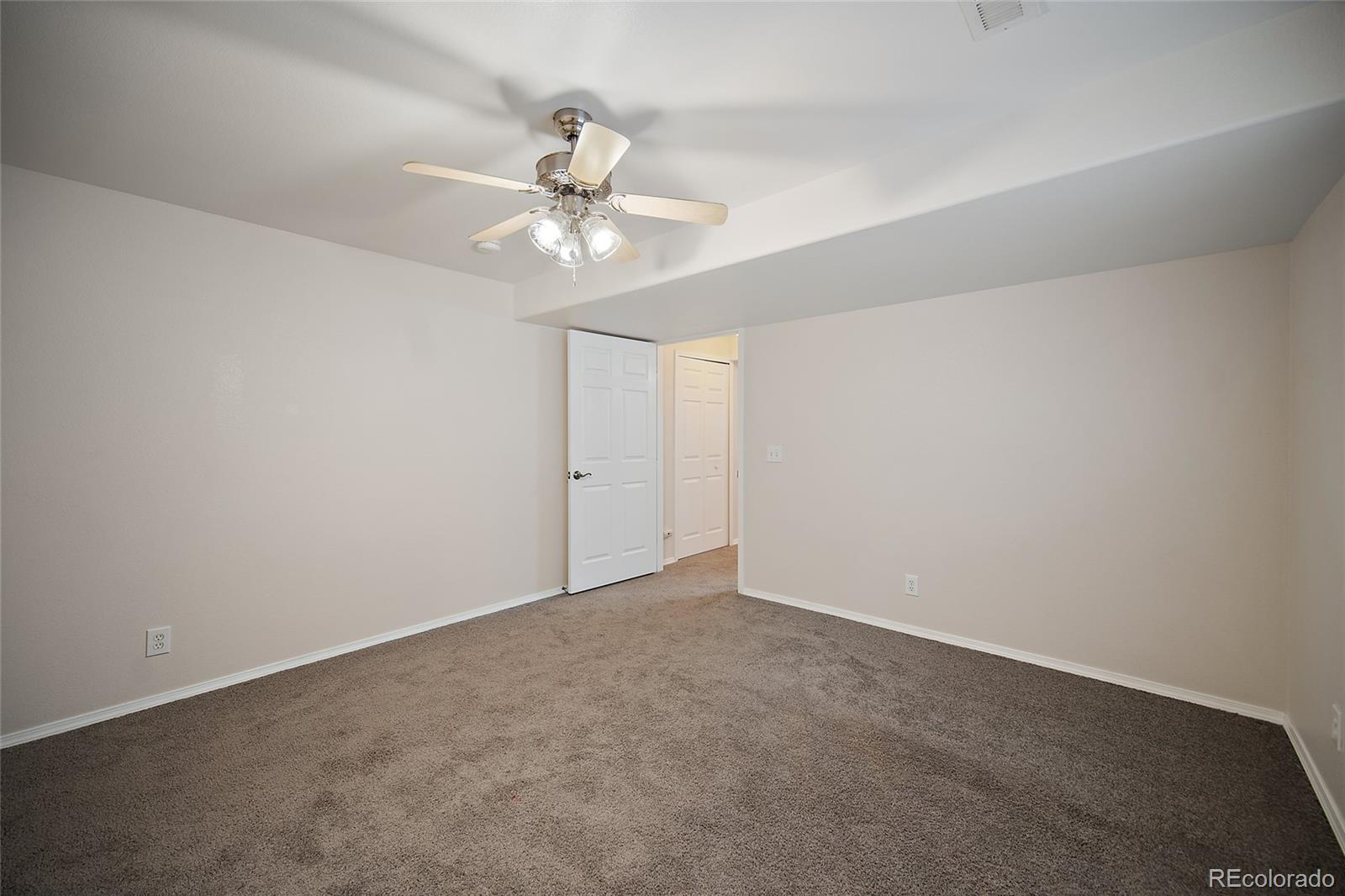 11360 Berry Farm Road Fountain, CO 80817 - Photo 35 of 44 an empty room with a chandelier fan and windows