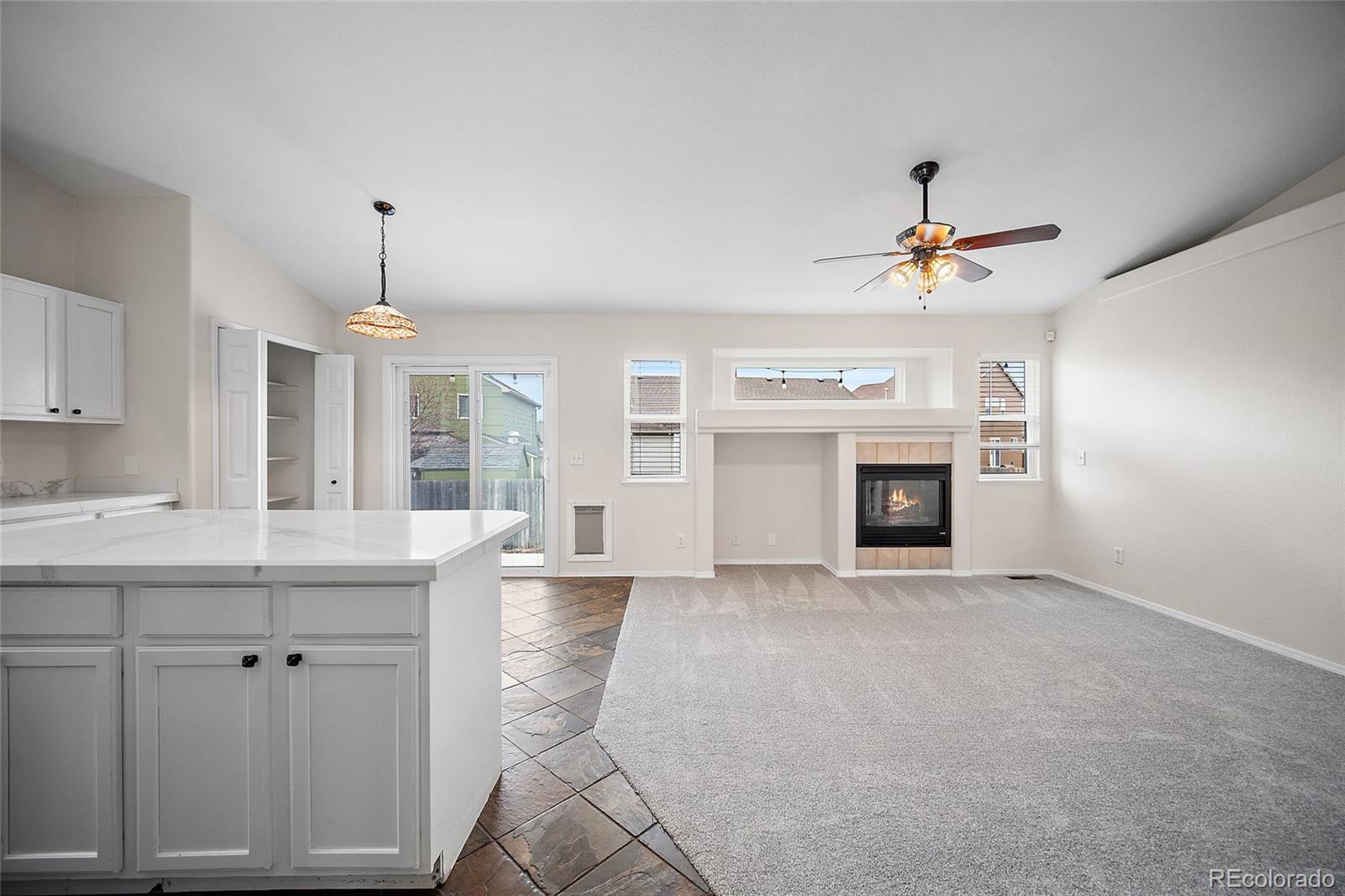 11360 Berry Farm Road Fountain, CO 80817 - Photo 8 of 44 a view of livingroom with kitchen island furniture and fireplace