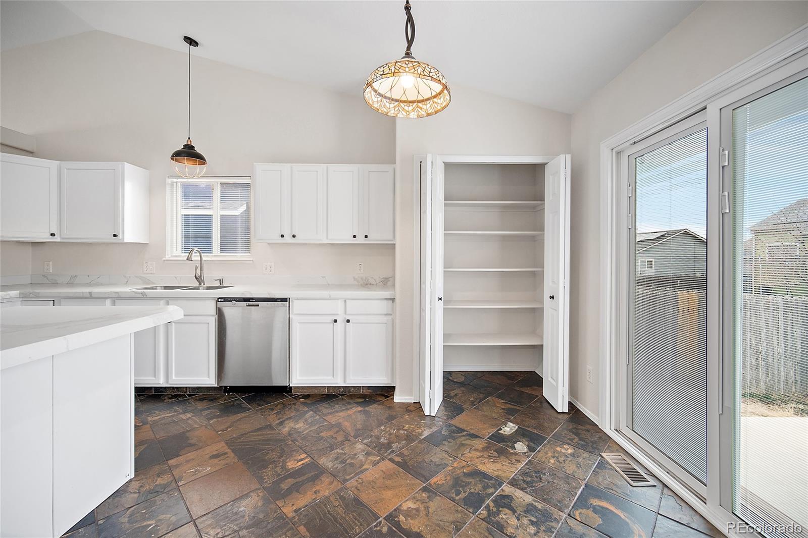 11360 Berry Farm Road Fountain, CO 80817 - Photo 10 of 44 a kitchen with kitchen island a sink window and cabinets