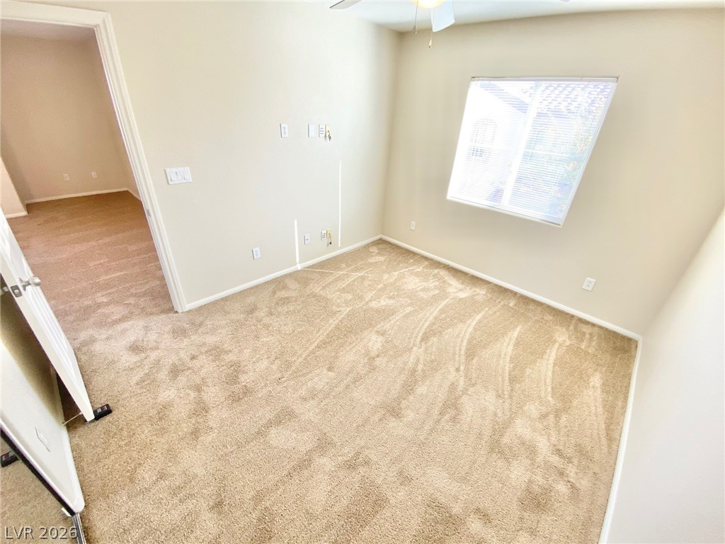 8569 Rhamus Court Las Vegas, NV 89149 - Photo 21 of 35 A well-lit bedroom features plush carpeting and a convenient ceiling fan for ultimate comfort.