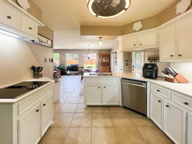 a kitchen with granite countertop a sink a stove and cabinets