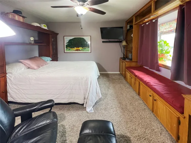 a bedroom with a bed and a large window