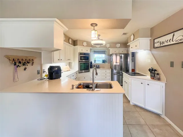 a large kitchen with a large counter top appliances and cabinets