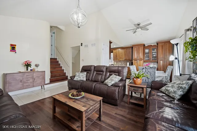 a living room with furniture a fireplace and a chandelier