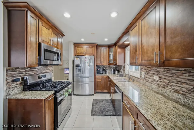 a kitchen with stainless steel appliances granite countertop a stove refrigerator sink and microwave