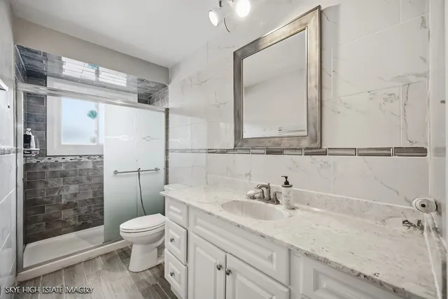 a bathroom with a sink a toilet and shower