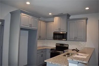 a kitchen with granite countertop a stove and a sink