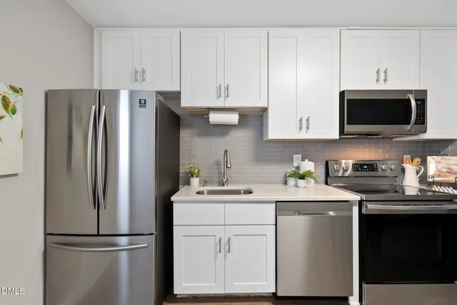 a kitchen with stainless steel appliances granite countertop a refrigerator stove a sink and dishwasher with wooden cabinet